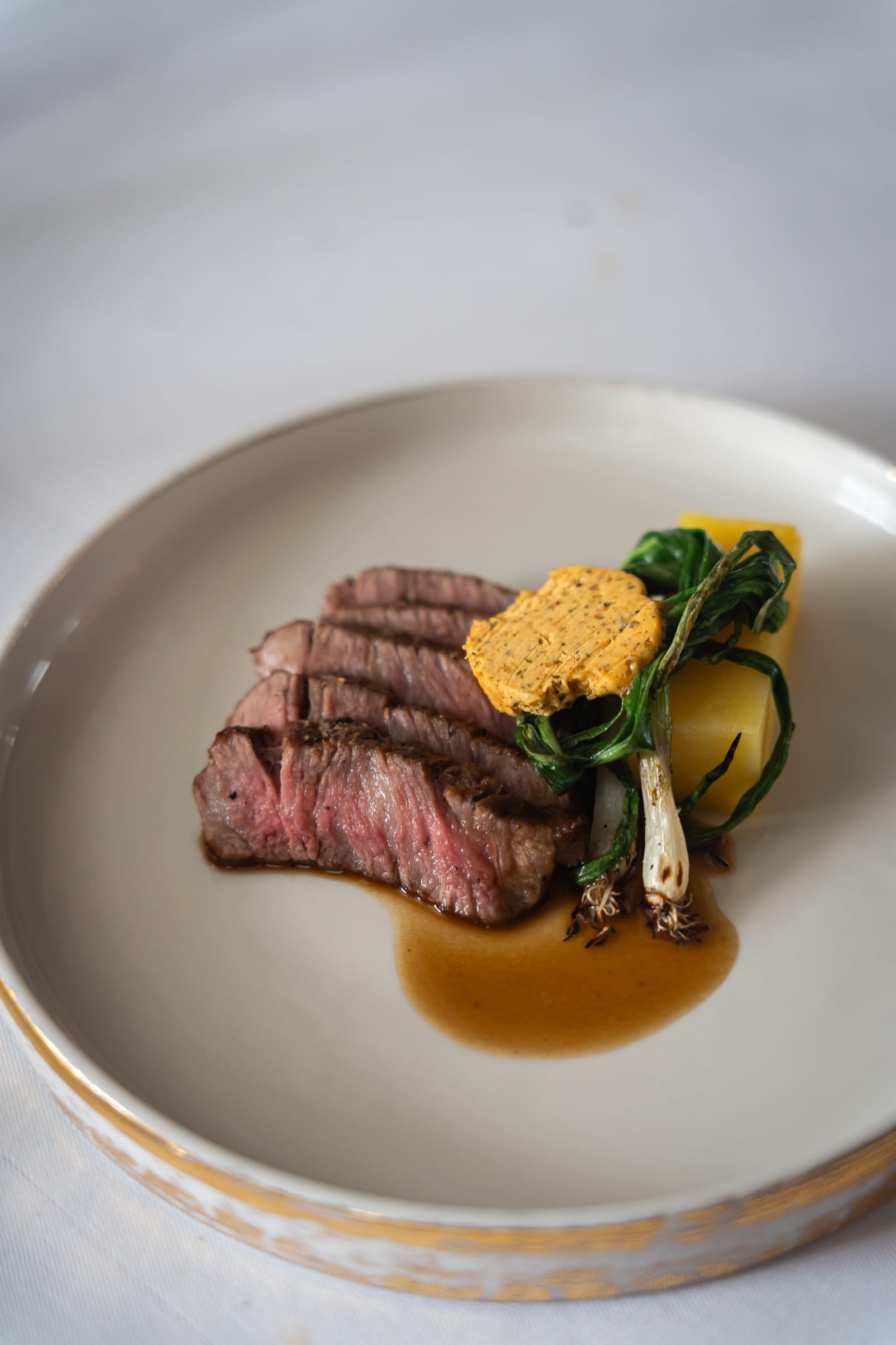 A wedding main meal dish of filet mignon steak with potato gratin and vegetables