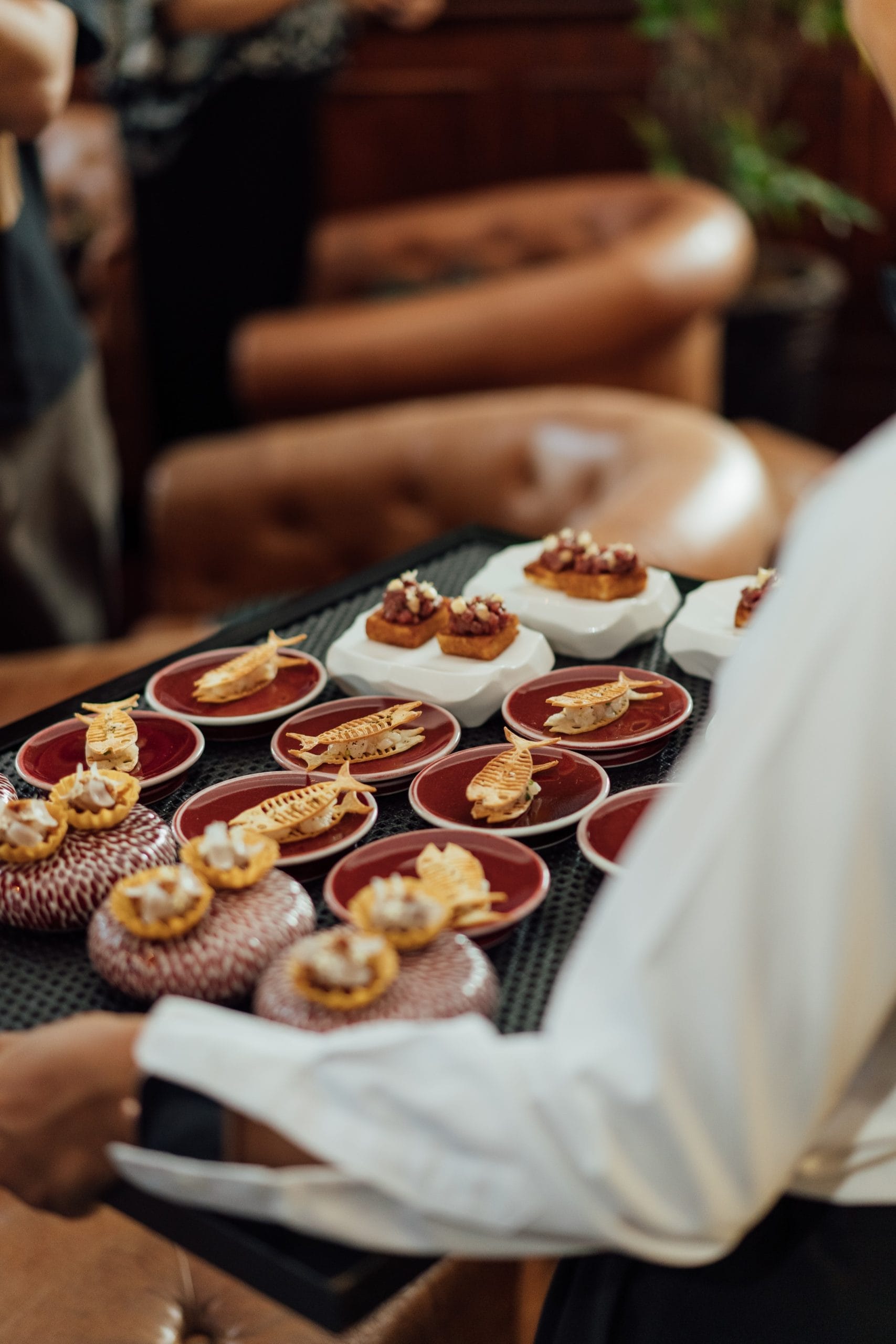 Corporate event catering Bali service with a caterer carrying a tray of gourmet Canapés.