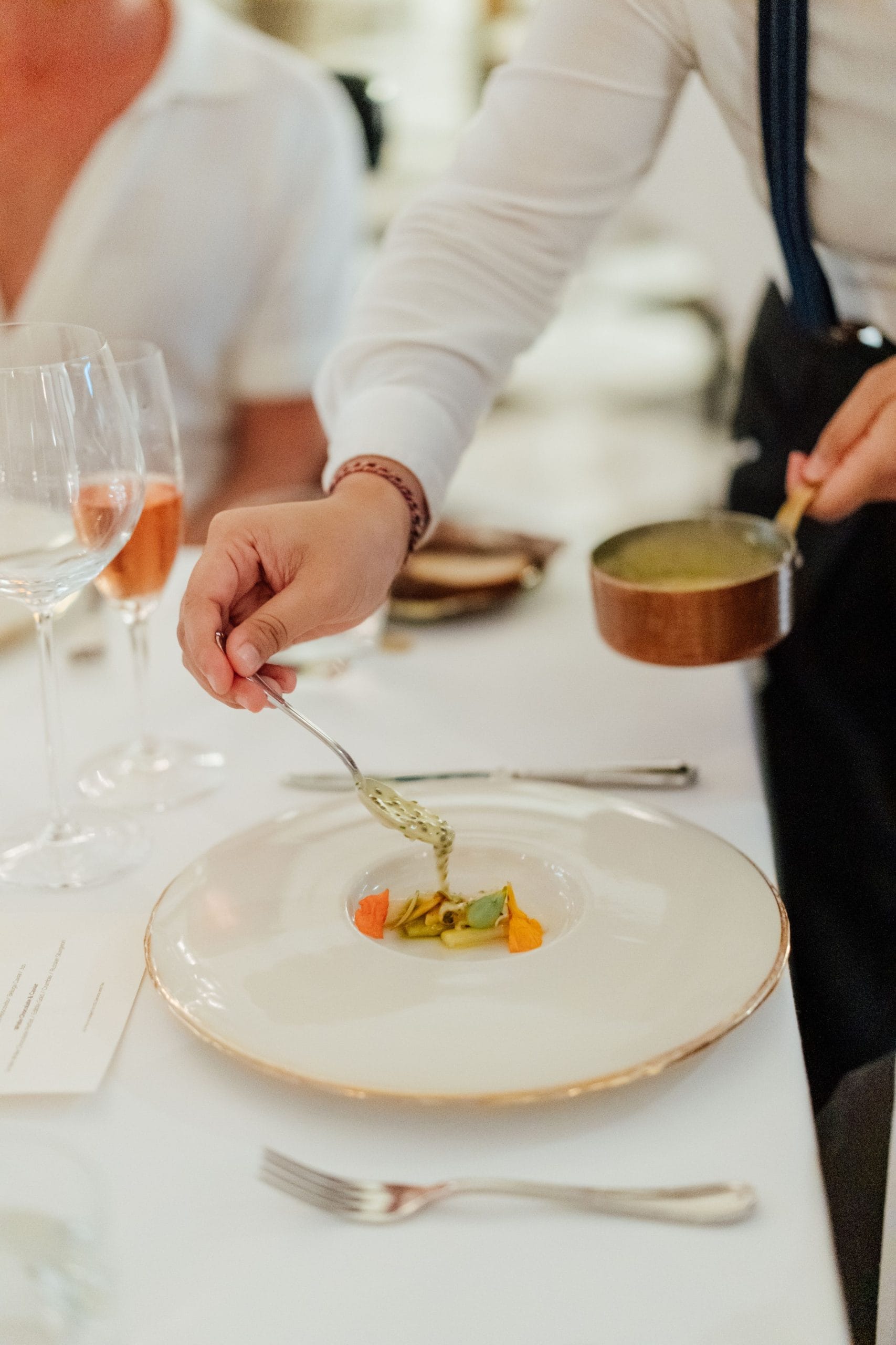 A chef drizzling a topping on a dish at a corporate catering retreat in Bali
