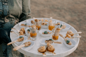 A caterer holding a plate of canapés