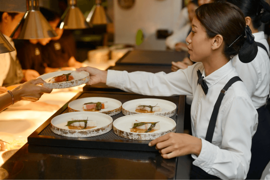 A Bali caterer serving plates 