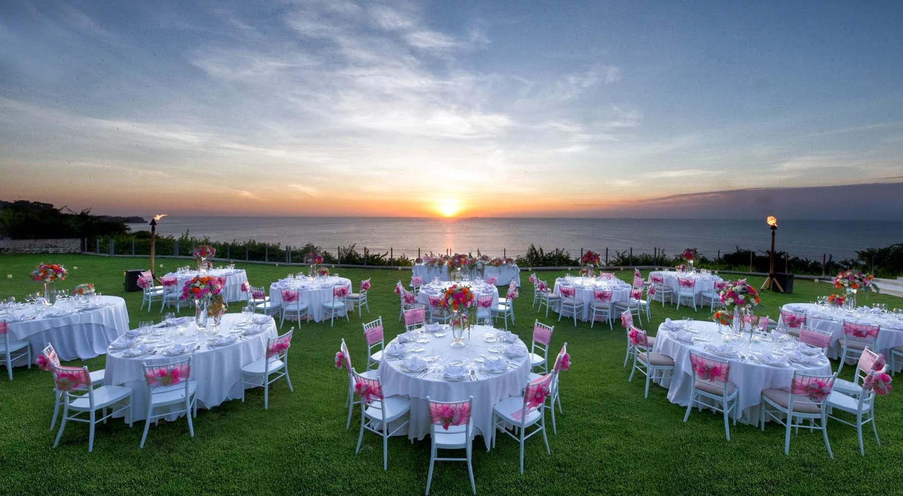 Tables set up by the sea for a wedding