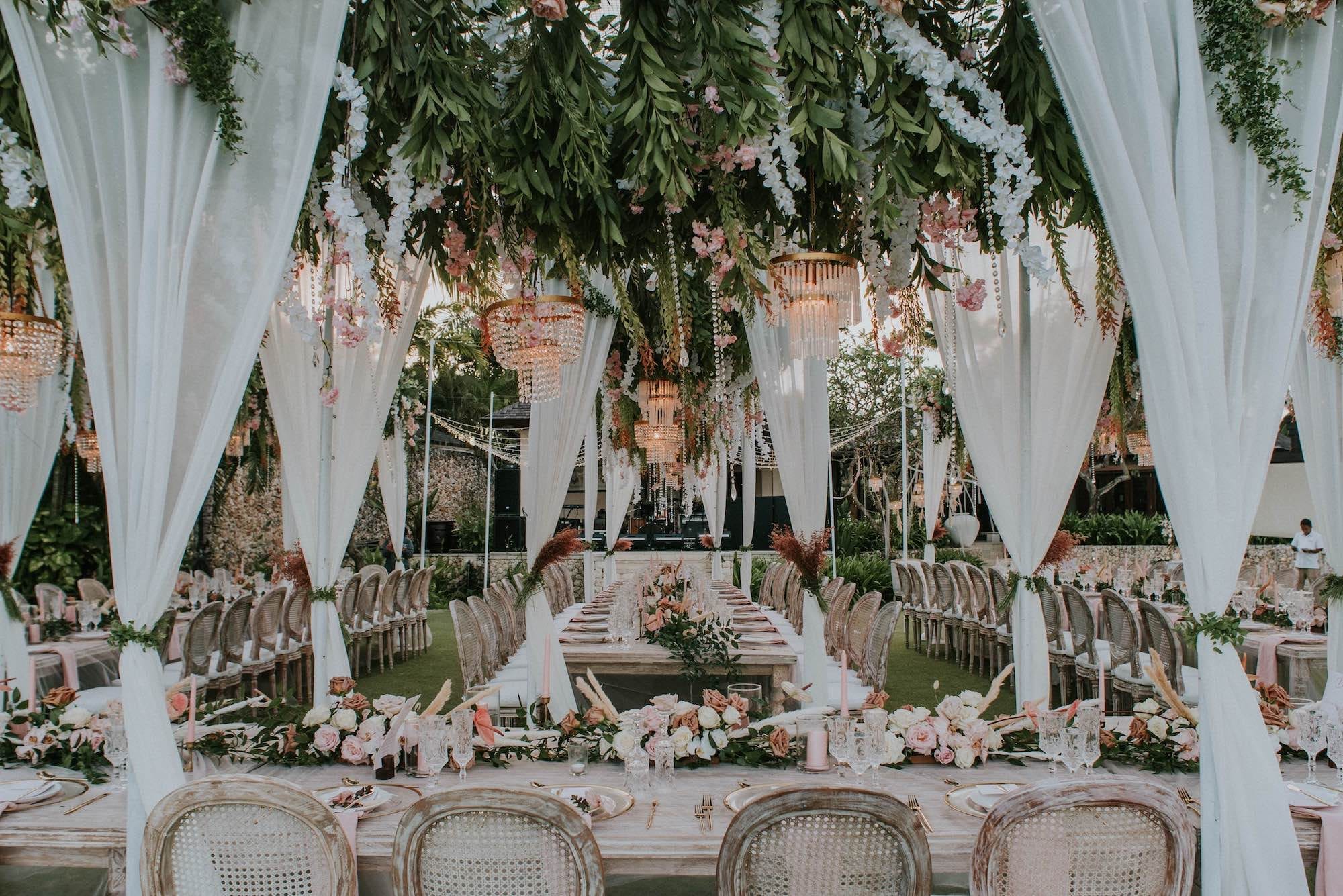 An elegant wedding in Bali with table settings decorated with flowers