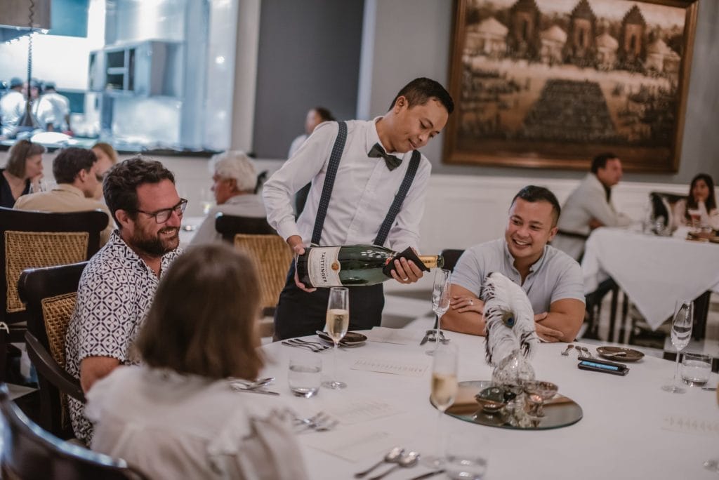 Guests being served sparkling wine by a caterer at a wedding in Bali