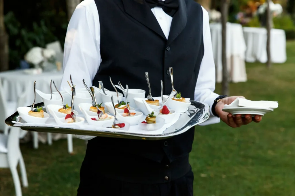 A caterer holding a tray of Canapés at a wedding