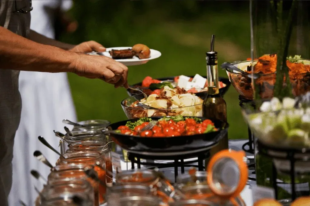 A guest serving themselves from a selection of catered dishes
