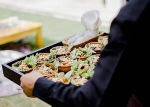 A caterer in Bali carrying a tray of canapés