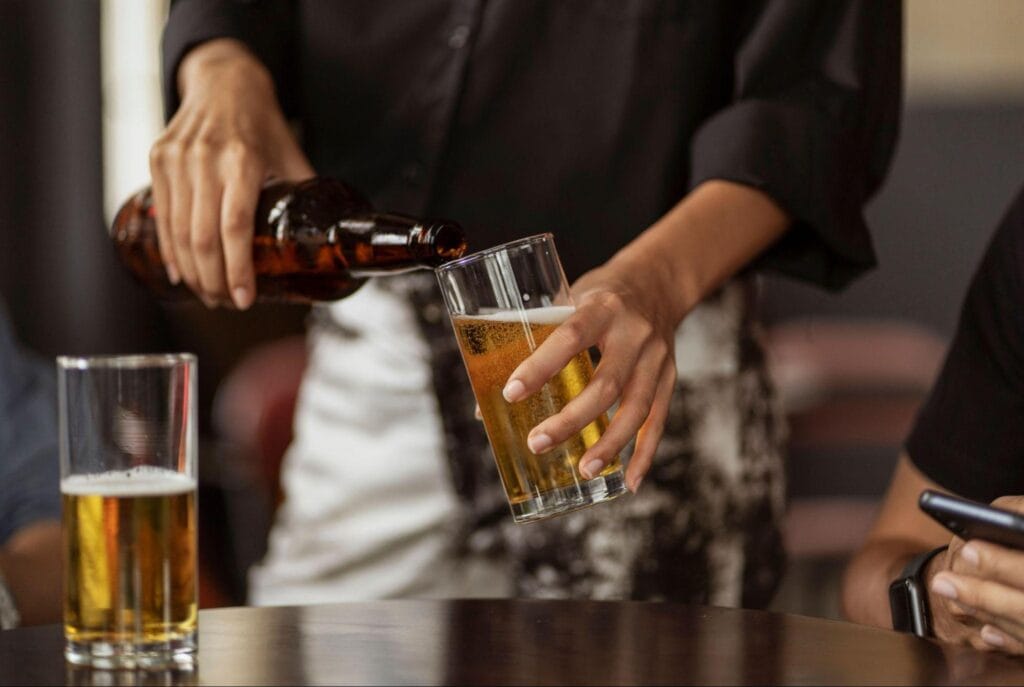 A bartender pouring a beer into a glass
