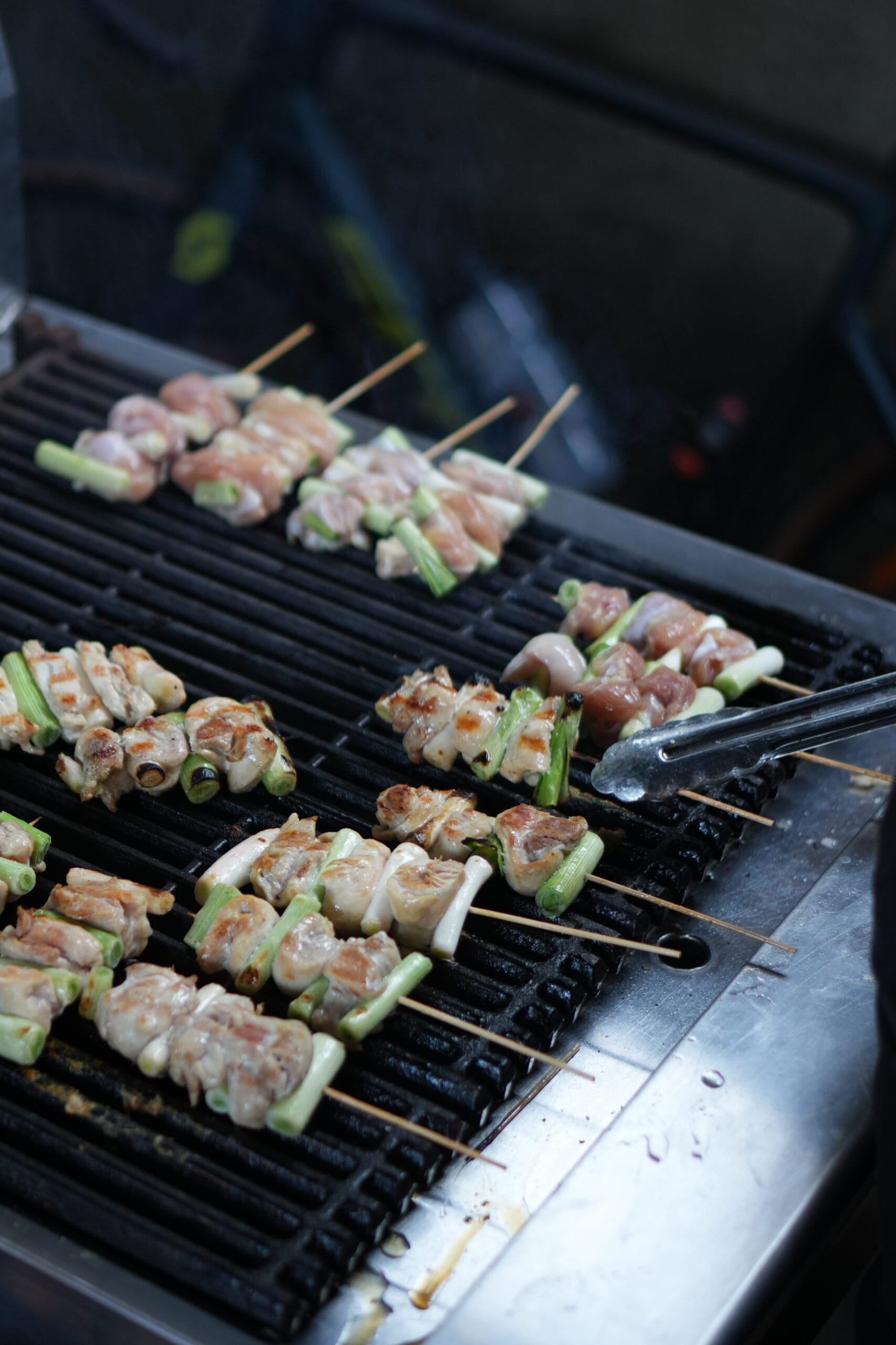 Kebab sticks grilling at a catered event in Ubud