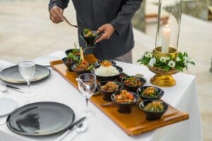 A caterer serving various dishes of food