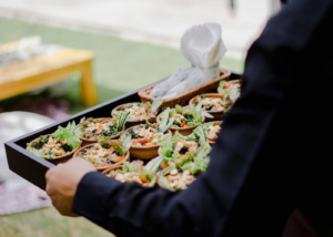 A caterer carrying a tray of snacks